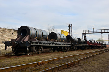 Fototapeta na wymiar Long strips of sheet metal rolled into large rolls, loaded and transported on rail cars.