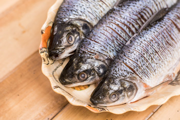 fresh fish served on a plate on a wooden table