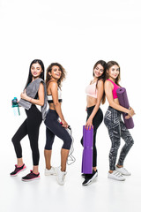 Fototapeta premium Four women standing together smiling looking at camera girls drinking water after power training or yoga session feels happy and satisfied. Healthy lifestyle concept