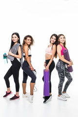 Fototapeta premium Four fitness girls in sportwear holding exercises equipment isolated on white background