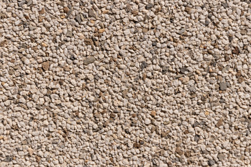 Fragment of a wall covered with crumbling white marble intersper