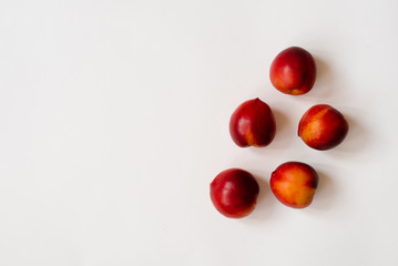 Fresh organic nectarines lie on a white background. Copy space. The concept of healthy and healthy food, fruit