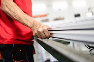 Manual worker assembling PVC doors and windows. Manufacturing jobs. Selective focus. Factory for aluminum and PVC windows and doors production.
