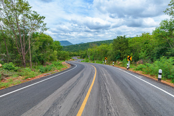 Fototapeta premium Asphalt road and mountains landscape with clouds
