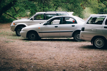 Fototapeta na wymiar Three cars parked in a clearing in the forest, camping in the forest