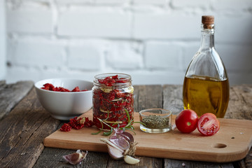 Sun-dried tomatoes with Provencal herbs, garlic and olive oil on a rustic wooden surface, selective focus
