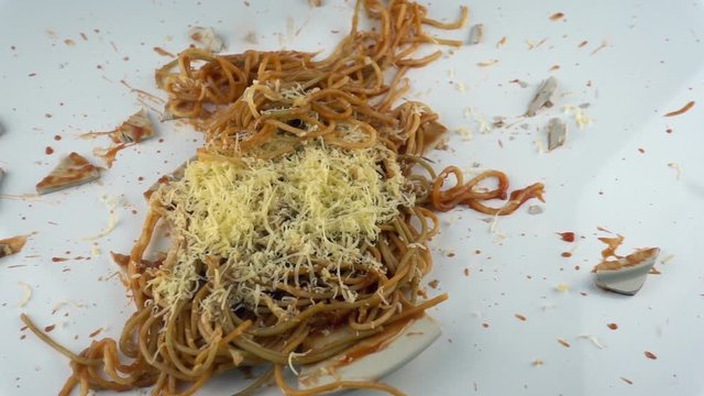 The concept of destruction. Falling and breaking plate with pasta in slow motion.
