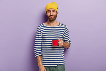 Photo of sleepy dissatisfied man has morning routine, being tired after sleepless night, wears...