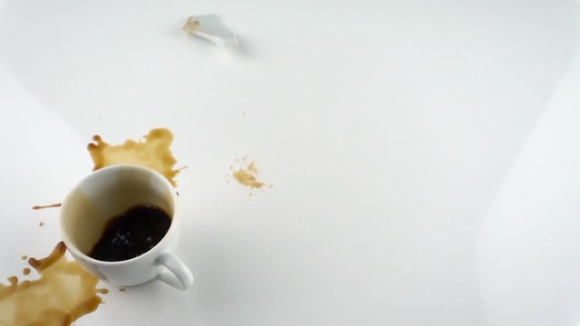 The concept of destruction with copy space. Falling and breaking cup of coffe in slow motion.