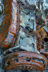 Old rusty engine lying among stones in the water.