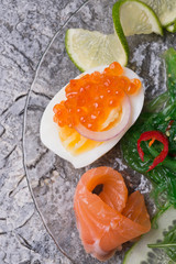 fresh  gourmet salad with  salmon, caviar, eggs and vegetables.   Protein luxury delicacy  healthy food. beautifull served around grey background.  close up