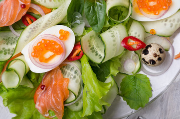 fresh  gourmet salad with  red  salmon caviar and  eggs and vegetables.  Protein luxury delicacy  healthy food. beautifull served at white table.