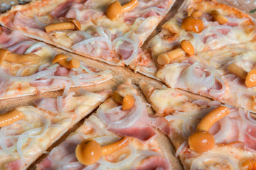 pizza with ham, mushrooms and onions on a wooden plate