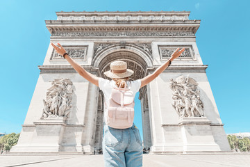 Happy Asian tourist girl enjoys the view of the majestic and famous Arc de Triomphe or Triumphal...