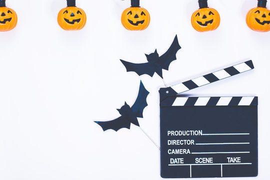 Clapperboard next to Halloween pumpkin. Jack O 'Lantern, pumpkin basket. Copy space. Garland on helluin. View from above. flat lay.