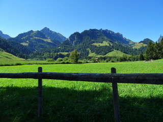 Fototapeta na wymiar Panoramic view of a landscape with mountains and wooden fence in the foreground