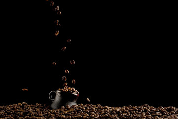 A cup with coffee beans in the air flying in flight like a spray. On a black background, coffee shop advertising concept, copy space.