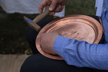 the man making pattern on the copper plate