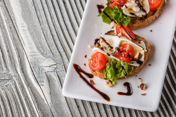 Bruschetta with tomatoes, lettuce, camambert, balsamic vinegar