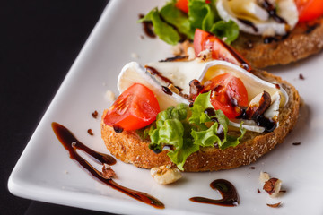 Bruschetta with tomatoes, lettuce, camambert, balsamic vinegar