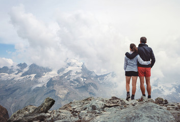 Couple embracing while looking at the mountains, italian Alps. Italy