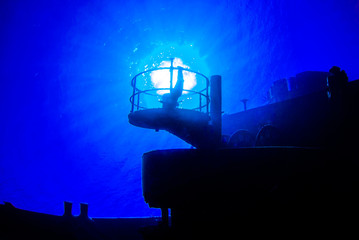 A scuba diver has taken a photo of the sun set against an aspect of a sunken shipwreck. The significance is that the section of wreck where the sun can be seen used to be a fitting for a searchlight