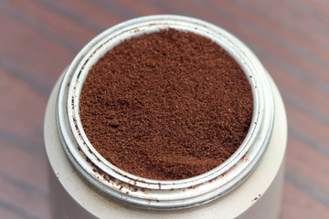 Natural coffee powder in aluminum cans on wooden table, top view.