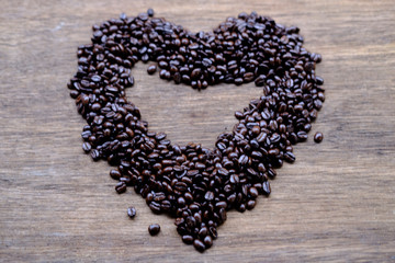coffee beans in shape of heart on wooden table