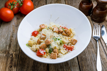 Caesar salad with salmon on a white plate