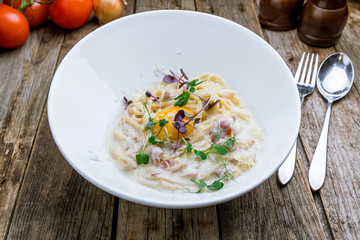Spaghetti Carbonara with bacon with egg on wooden table