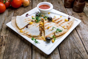 Mexican Quesadilla with chicken and sause on wooden table