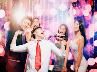 happy young group singing and dancing in party