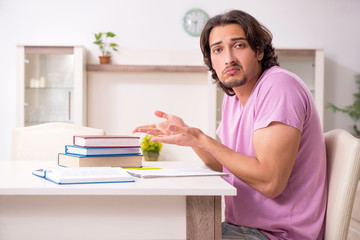 Young male student preparing for exams at home