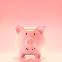 Smiling Piggybank on pink background. Saving money concept.