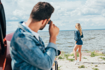 Fototapeta premium selective focus of blonde woman in denim shorts and jacket looking away