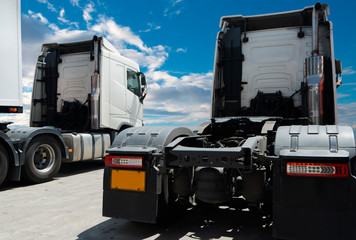 Fototapeta na wymiar white semi trucks parking at a blue sky, freight industry logistics and transportation.