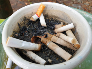 The ashtray is made of ceramic. With sand and many cigarette debris inside.top view picture.World No Tobacco Day