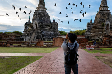 A man Photographer tourists are taking photos and traveling at the temple Wat Phar sri sanphet.
