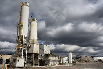 Portland cement factory silos with dark cloud sky