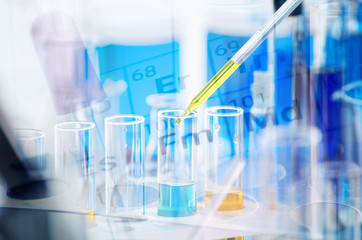 A pipette dropping sample into a test tube,abstract science background