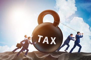 Businessman pulling kettlebell in tax concept