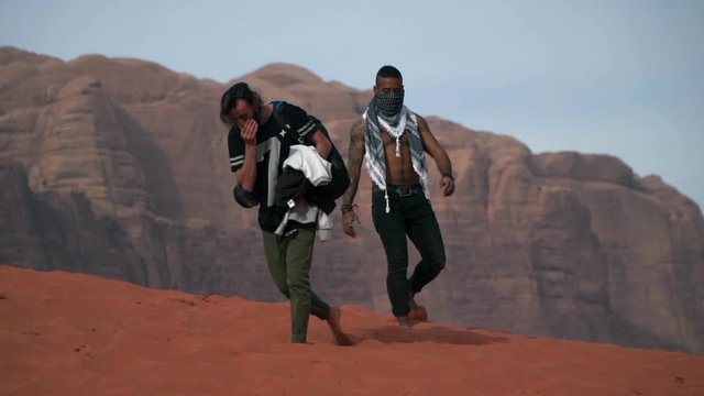 two backpackers walking through the middle of the wadi rum desert