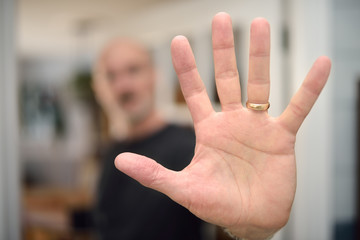 Blurred man putting hand up to camera to stop picture