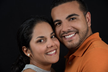 Portrait happy, smiling couple spending time together. Black background