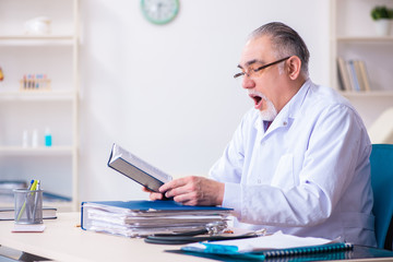 Old male doctor working in the clinic