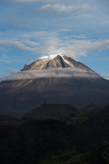 Beautiful view of the Tolima snowy peak in a bright blue sky with few clouds. Colombia