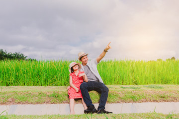 Father and daughter sit and watch the view in the middle of pure nature.