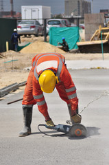 Man cutting concrete floor with diamond saw blade machine