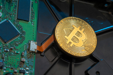 Digital crypto currency. Golden bitcoin lying on computer hardware.