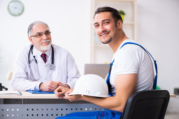 Young male contractor visiting old doctor